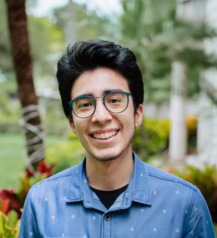 Portrait of Bryan Martinez in a blue button up shirt smiling.